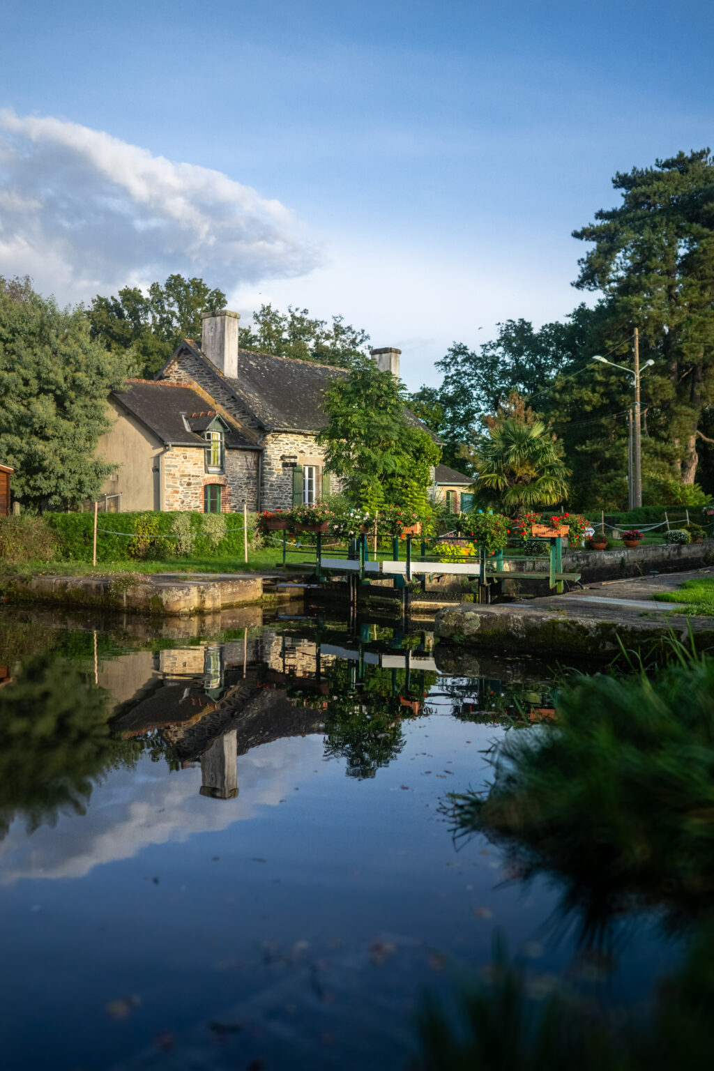 Maison éclusière fleurie se reflétant dans l’eau à Malestroit